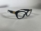 a pair of black cat eye glasses with gold accents on a white surface