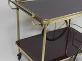 a small metal cart with a glass shelf on it