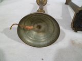 deux bougeoirs anciens en laiton posés sur une table blanche