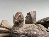 a statue of a bird sitting on top of a pile of books