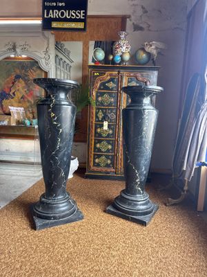 two black vases sitting on a carpet in a room
