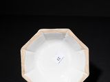 a close up of a white plate on a black surface