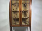 une vitrine ancienne avec des portes vitrées et un socle en bois