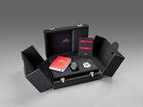 an image of a black box with a watch and other items in it