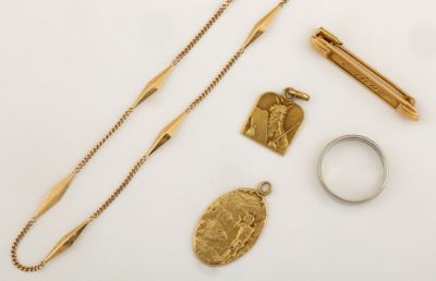 un collier en or, une bague et d'autres bijoux posés sur une surface blanche
