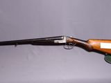 un vieux fusil avec un canon en bois et un étui en cuir