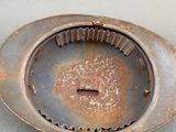 a rusted metal strainer with a hole in it