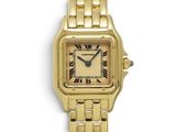 a close up of a gold wrist watch with roman numerals