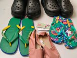 Plusieurs paires de sandales et de pantoufles sont alignées sur une table