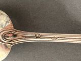 silver spoon with a curved handle on a black surface
