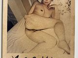 a polaroid picture of a naked woman on a bed