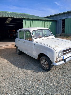 une vieille voiture blanche garée devant un immeuble