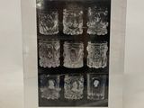 a box of twelve glass mugs with a picture of a man and woman on them