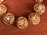 a gold bracelet that has a bunch of beads on it