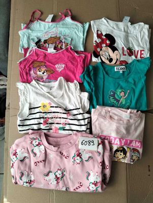 several children ' s pajamas and t - shirts laid out on a cardboard box