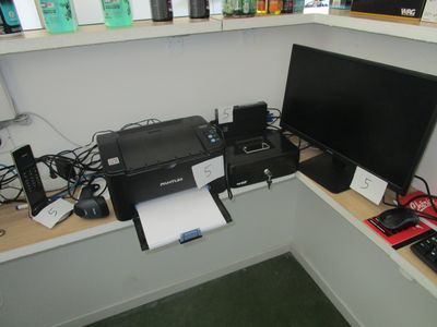a desk with a computer, printer, and other electronics on it