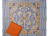 a blue and orange square scarf with a box on top of it