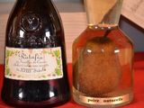 three bottles of wine and a pear on a table