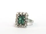 un gros plan d'une bague en tourmaline verte et diamants sur fond blanc