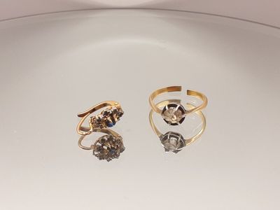 une paire de bagues en or et diamants posées sur une assiette blanche