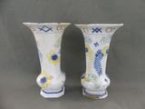 pair of blue and white vases with flowers on them on a gray background