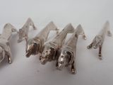 five silver figurines of elephants on a white surface