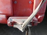 a close up of a red truck with a rope attached to the back of it