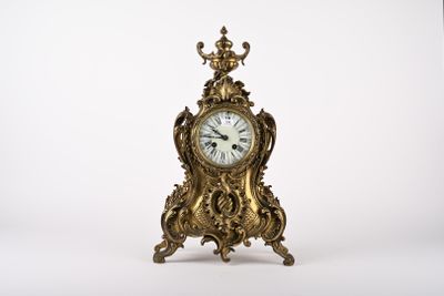 une horloge posée sur un support sur une surface blanche