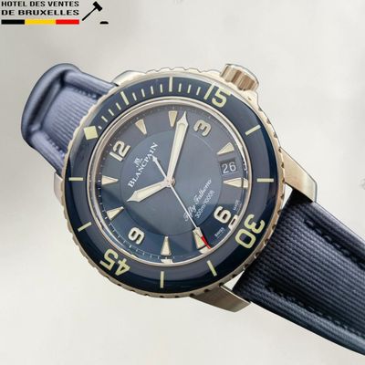 a close up of a wrist watch with a blue strap