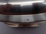 a silver plate with a silver handle on a table