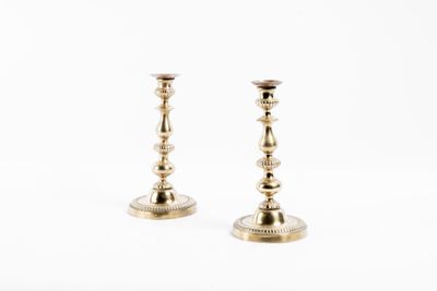 paire de chandeliers anciens en laiton sur fond blanc