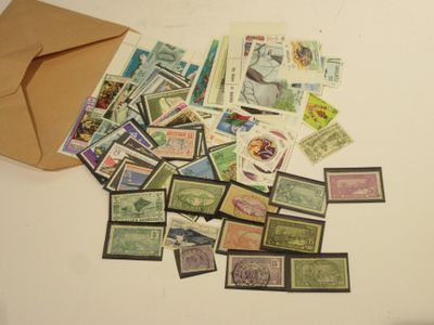 a lot of stamps on the table with a brown envelope