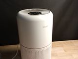 a white air purifier sitting on a wooden table