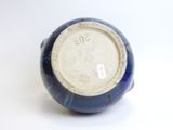a close up of a blue and white vase on a white surface