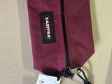 purple bag with a tag attached to it sitting on a table
