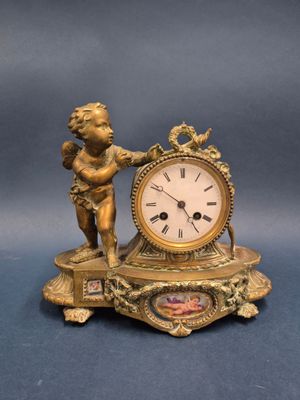 a gold clock with a cheren and a cheren on it
