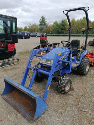 un tracteur bleu et un tracteur rouge sur un parking