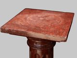 a close up of a small table with a red marble top