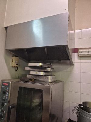 un micro-ondes argenté posé dans une cuisine, avec une casserole sur la cuisinière