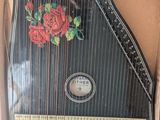 un instrument de musique très ancien, rangé dans une boîte ornée d'un motif de rose