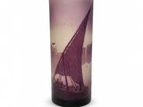 un vase violet orné d'un bateau, posé sur un fond blanc