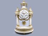 une horloge blanche et or posée sur une table