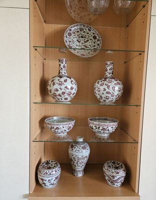 de nombreux vases et bols posés sur une étagère dans un meuble