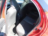 a red car with its door open and a black seat