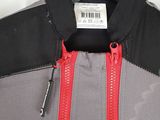 the back of a gray and red jacket hanging on a hanger
