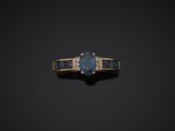 a blue sapphire and diamond ring on a black background