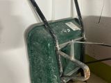 a green wheelbarrow with a yellow wheelbarrow on the side of it
