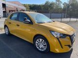 a yellow car parked in a parking lot next to a fence