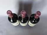 three bottles of wine are lined up on a table