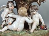 a figurine of a group of children sitting under a tree